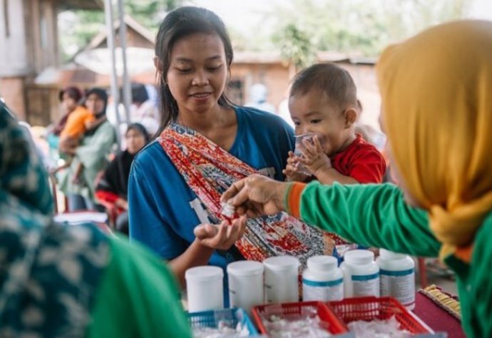 A woman receives medicines for lymphatic filariasis during a mass drug administration for lymphatic filariasis in South Sumatra, Indonesia © RTI International/ Muhammad Fadli