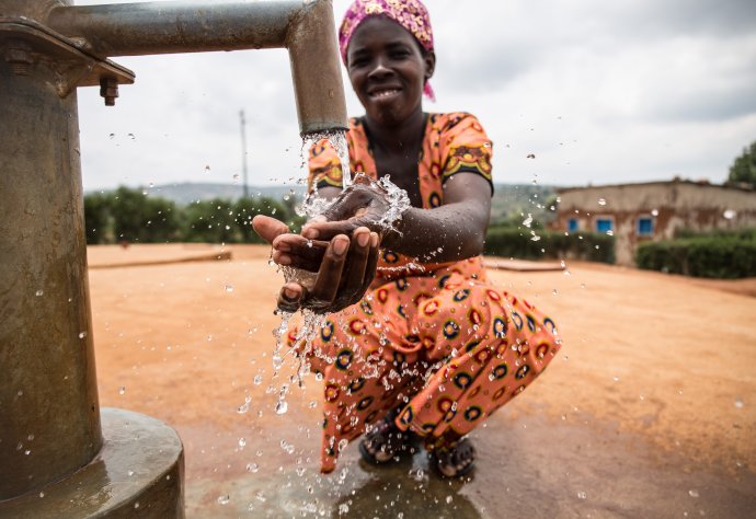 A WaterAid trained pump mechance and local leader, Gaudence Mukahabyarimana, washes her hands at the handpump in Nkange, Rwanda, February 2018. Credit: WaterAid/ Jacques Nkinzingabo