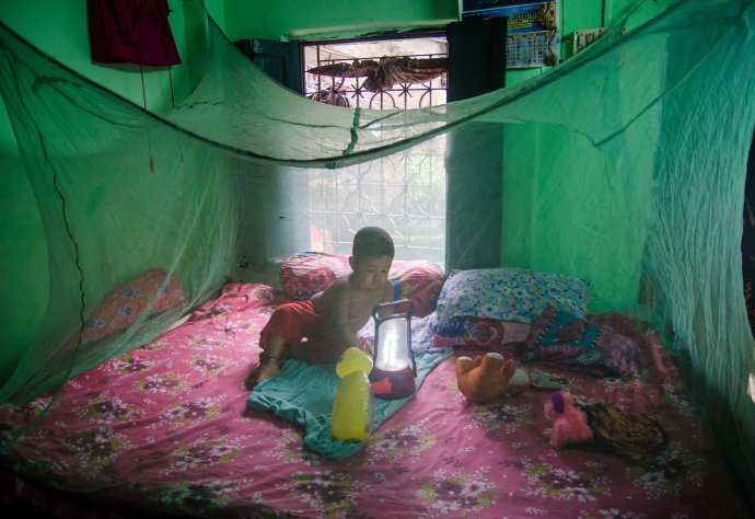 A boy, aged two, plays inside a mosquito net in Kolkata, West Bengal, India. Photo: Sudip Maiti