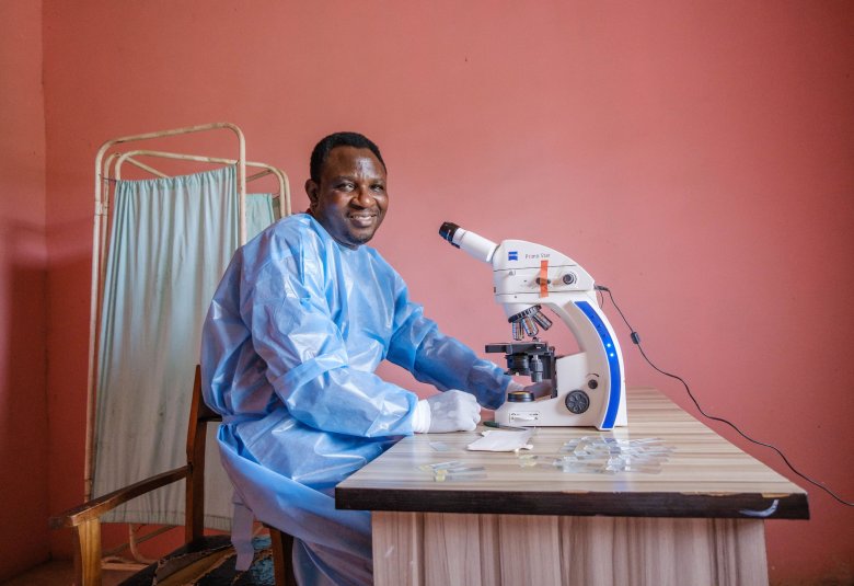 A scientist sits in front of a microscope, at a lab desk at Primary Health Post at Irele Local Government area in Ondo State, Nigeria.