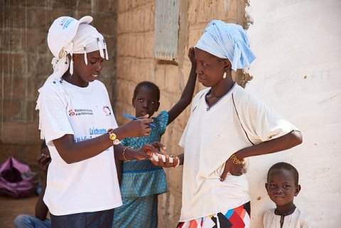 During a mass drug administration in Touba, Senegal, a health worker explains the dosage of Zithromax, a trachoma-fighting antibiotic, to Mbène Dieng at her home.&nbsp;© RTI International/Sam Phelps