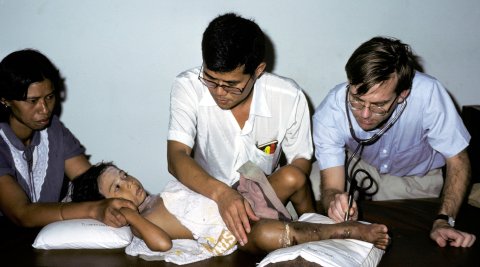 Sornchai Looareesuwan and Rodney Phillips assessing a child bitten by a Malayan pit viper in Trang, Southern Thailand, 1985