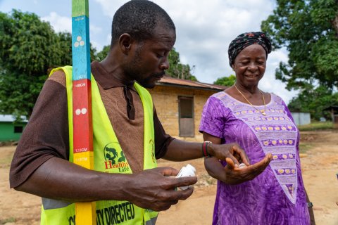 Community Volunteer Victor Scott gives Hawa Barclay treatment to protect her against onchocerciasis in Gbarpolu Liberia. Photo: Sightsavers/ Carielle Doe Community Volunteer Victor Scott gives Hawa Barclay treatment to protect her against onchocerciasis in Gbarpolu Liberia. Photo: Sightsavers/ Carielle Doe