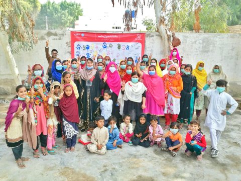 IRD Pakistan’s Sujaag team with families in Village Jumo Agham, Ratodero Town, after signing a pledge wall fostering inclusivity of those with lived experiences of HIV. Credit: Credit: Muhammad Sarang Ali Abro 